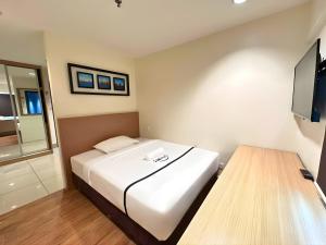 a hotel room with a bed and a television at Seeds Hotel Premier Pudu TRX Kuala Lumpur in Kuala Lumpur