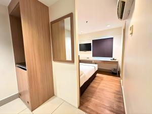 a hotel room with a bed and a mirror at Seeds Hotel Premier Pudu TRX Kuala Lumpur in Kuala Lumpur