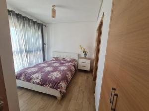 une petite chambre avec un lit et une fenêtre dans l'établissement Cozy 2 Bedroom Prestigia - close to Plage des Nations, à Sidi Bouqnadel 6 autres photos