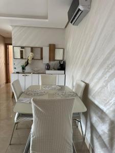- une table et des chaises dans une pièce avec cuisine dans l'établissement Cozy 2 Bedroom Prestigia - close to Plage des Nations, à Sidi Bouqnadel