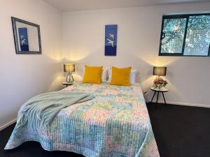 ein Schlafzimmer mit einem Bett mit einer bunten Bettdecke und zwei Lampen in der Unterkunft Seaview Akaroa in Akaroa
