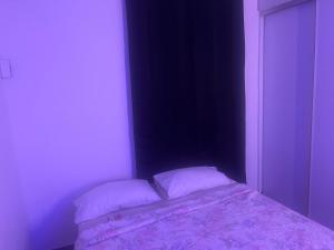 a bed in a room with two pillows on it at Appartement Dream in Fort-de-France