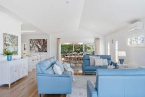 a living room with blue chairs and a kitchen at Crestmount in Milton