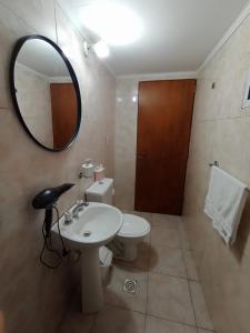 a bathroom with a sink and a mirror and a toilet at Departamento en Dolores Precio exclusivo en entrada a Parque Termal in Dolores