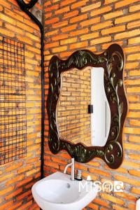 a mirror on a brick wall with a sink at Chloe's Room 