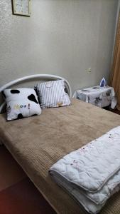 a bed with pillows on it in a room at квартира жубанова in Aktobe
