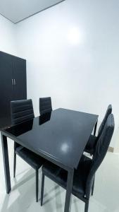 ein schwarzer Esstisch mit vier schwarzen Stühlen in der Unterkunft SM 3 Cozy Corner Retreat in Sampong + 2 Fotos