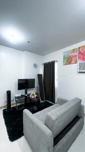 ein Wohnzimmer mit Sofa und Fernseher in der Unterkunft SM 3 Cozy Corner Retreat in Sampong
