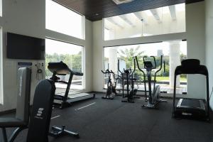 a gym with cardio equipment and a large window at Relaxing 2BHK with Mangrove View - Family-Friendly, Pool - Candolim Beach in Candolim