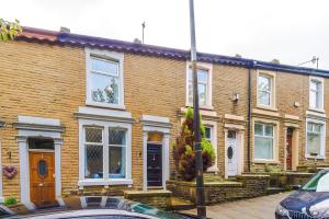 a brick house with a car parked in front of it at Bright & Spacious 4-Bed Home in Darwen Town by Eason Stays, Perfect for Contractors, Business Travellers & Groups - with Free Parking! in Darwen