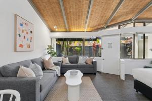 a living room with a couch and a table at Hibiscus Villa - Beachfront, 2 pools, Tennis, Restaurant in Kororo Basin +22 photos