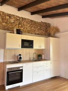 a kitchen with white cabinets and a microwave at Cabernet Rural in Sant Jaume dels Domenys +12 photos