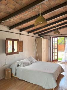 a bedroom with a bed in a room with wooden ceilings at Cabernet Rural in Sant Jaume dels Domenys