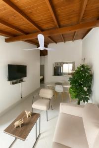 ein Wohnzimmer mit weißen Möbeln und einer Decke in der Unterkunft Casa Bosques in Pilarica - Family and cozy in Medellín