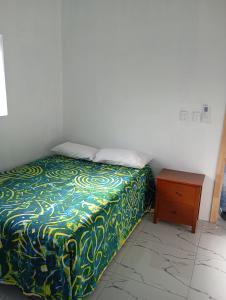 ein Schlafzimmer mit einem Bett und einem Nachttisch in der Unterkunft Tropical Hideaway in Amuri