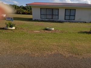 ein Hof mit einem Haus und einem Rasen mit einigen Pflanzen in der Unterkunft Tropical Hideaway in Amuri