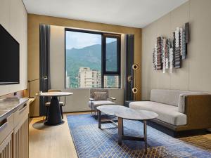 a living room with a couch and a tv at Four Points by Sheraton Fuzhou, Jin’an in Fuzhou