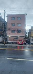 un'auto rossa parcheggiata davanti a un edificio di Apê Aconchegante 2 a Recife