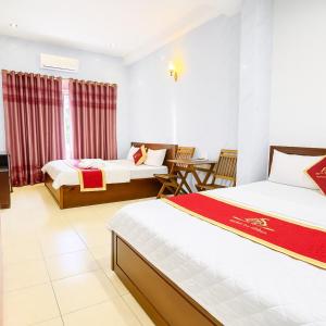 a hotel room with two beds and a table at Duy Khang 1 Hotel in Ho Chi Minh City +19 photos