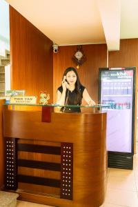 a woman talking on a cell phone at a counter at Duy Khang 1 Hotel in Ho Chi Minh City
