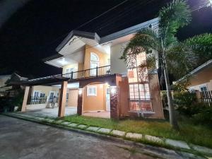 een huis met een palmboom bij Panglao Ramyer Villa 1 in Sampong