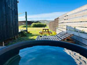 a pool of water with a picnic table and a wooden fence at Nomad Tiny Matanzas in Navidad