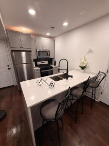 a kitchen with a sink and a counter with chairs at Bluehouse in East Chicago