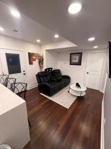 a living room with a black couch and a table at Bluehouse in East Chicago +6 photos