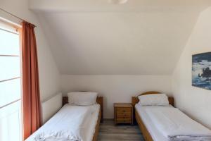 two beds in a room with a window at Ferienhaus Rügentraum in Glowe