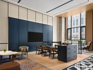 a lobby with a table and chairs and a tv at Four Points by Sheraton Fuzhou, Jin’an in Fuzhou