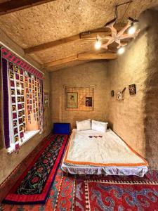 a bedroom with a large bed and a ceiling fan at JAPAR guest house in Bokonbayevo