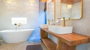 Un baño con dos lavabos, una bañera y un espejo. en Recently renovated 3BR apartment near Layan Beach, en Phuket 12 fotos más