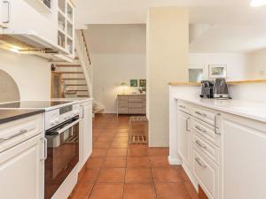 a kitchen with white cabinets and a tile floor at Luxury Retreat in Blavand - By Traum Ferienwohnungen in Blåvand