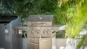 Una estufa y un bote de basura al lado de una palmera en Recently renovated 3BR apartment near Layan Beach, en Phuket
