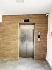 a metal elevator in a building with a wooden wall at Jardines III LAUREL 302 in Punta Cana