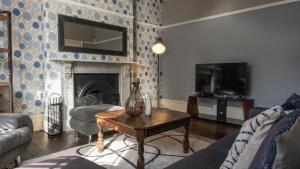 ダービーにある6 BDR House By Eason Stays Short Lets & Serviced Accommodation Derby With Free Parkingのテーブルと暖炉のあるリビングルーム