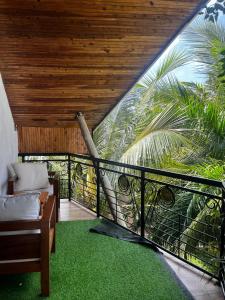 a balcony with a couch and a palm tree at Diani Savanna Sunset Studio Apartment in Diani Beach