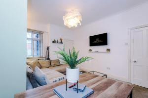 un salon avec un canapé et une table dans l'établissement Four BR House By Eason Stays Short Lets & Serviced Accommodation Worsley With Free Parking, à Worsley