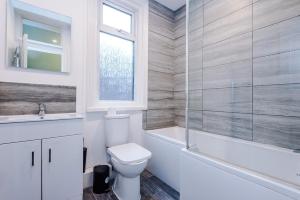 une salle de bain avec toilettes, baignoire et lavabo dans l'établissement Four BR House By Eason Stays Short Lets & Serviced Accommodation Worsley With Free Parking, à Worsley 55 autres photos