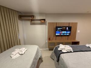 a hotel room with two beds and a flat screen tv at 509 Flat praia piscina barzinho Intermares in Cabedelo +17 photos