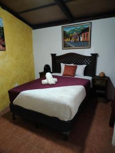 een teddybeer op een bed in een slaapkamer bij Casa Mashallah Antigua Guatemala in Antigua Guatemala