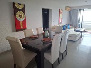 a living room with a dining room table and chairs at Apartment on Beach, Stunning Views, Rayong in Ban Phayun +39 photos