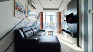 a living room with a leather couch and a television at 2BR The BCC Residence 7AC City View in Nagoya