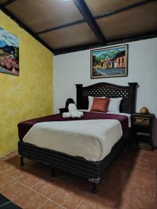 een slaapkamer met een bed met een knuffeldier erop bij Casa Mashallah Antigua Guatemala in Antigua Guatemala