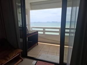 a room with a view of the ocean through a glass door at Apartment on Beach, Stunning Views, Rayong in Ban Phayun