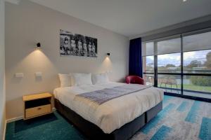 a bedroom with a bed and a large window at MJ McMahon Motel in Wonthaggi