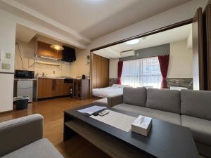 a living room with a couch and a table at Laforet Tokaichi in Hiroshima