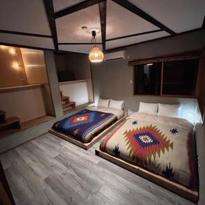 - 2 lits dans une chambre dotée de parquet dans l'établissement 一棟貸し宿月灯草津, à Kusatsu