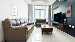 ナゴヤにある3BR The BCC Residence 1012 City Viewのリビングルーム(革張りのソファ、テレビ付)