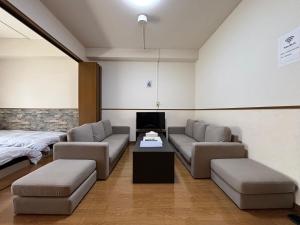 a living room with two couches and a bed at Laforet Tokaichi in Hiroshima